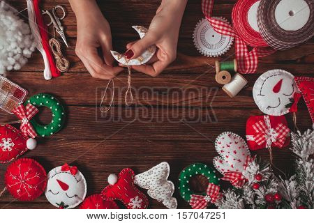 felt Christmas decorations on the wooden table - woman is preparing for handmade