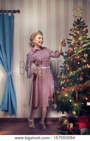 portrait of nice young woman hanging around christmas tree on x-mas  eve