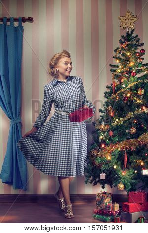 portrait of nice young woman hanging around christmas tree on x-mas  eve