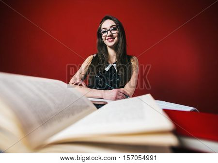 Young attractive brunette happy girl in glasses studying with book