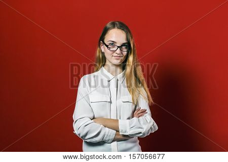 attractive happy smiling student blonde girl in white shirt with books on red background, student concept