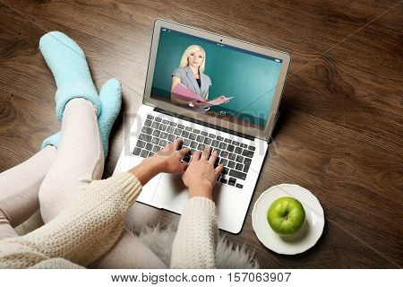 Woman video conferencing with tutor on laptop at home. Distance education concept.