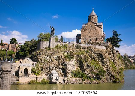 Medieval Metekhi Church and Vakhtang Gorgasali monument on the top of the rocky hill near Kura River in Tbilisi, Georgia. Europe.