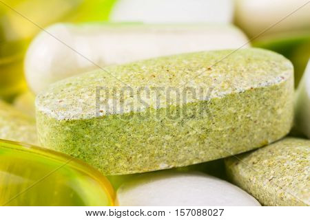 Mixed natural food supplement pills omega 3 multivitamin and glucosamine capsules macro image