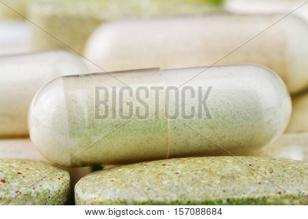 Mixed natural food supplement pills multivitamin and glucosamine capsules macro image