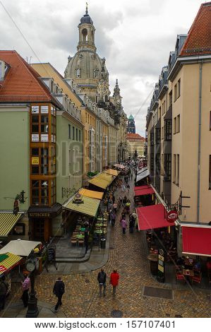 DRESDEN GERMANY - SEPTEMBER 21 2013: the Pedestrians in the Munzgasse alleyway. The historic cobblestone alley is lined with many of Dresdens most famous restaurants and cafes.