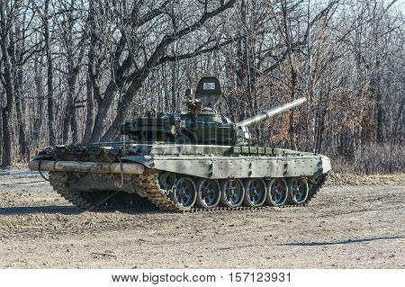 Russian tank rides on a forest road