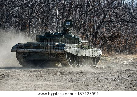 Russian tank rides on a forest road