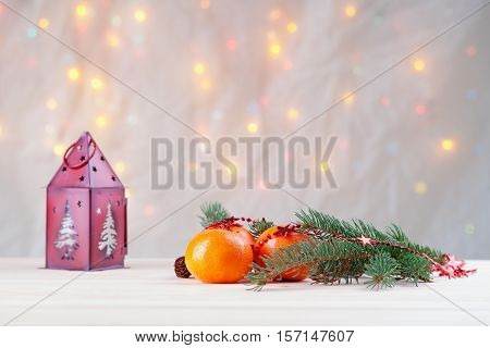 Mandarins with fir-tree branch and house shaped candlestick