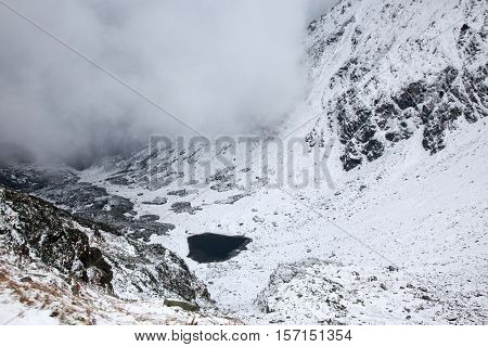 view on foggy valley in winter from Rodna Mountains in Transylvania - Romania