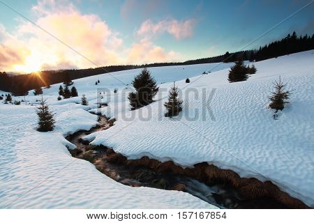 winter sunset over snow mountains with river Germany