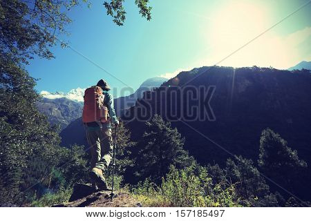 young woman backpacker trekking at the himalaya mountains