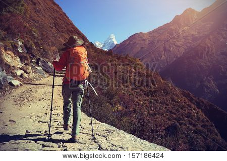 young woman backpacker trekking at the himalaya mountains