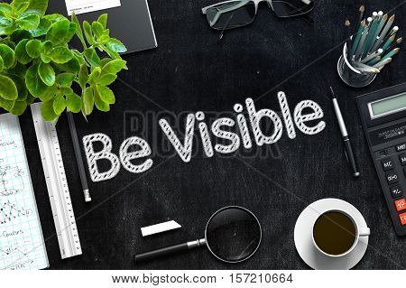 Be Visible Handwritten on Black Chalkboard. Top View of Black Office Desk with a Lot of Business and Office Supplies on It. 3d Rendering. Toned Image.