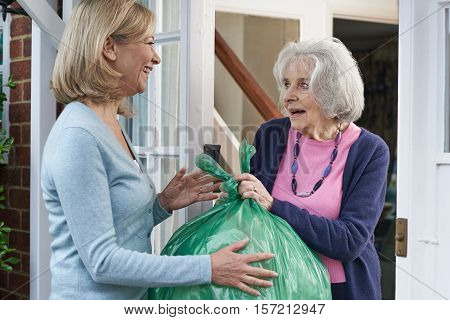 Woman Taking Out Trash For Elderly Neighbour