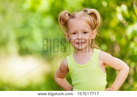 Close-up portrait of smiling three years old girl standing and looking at camera