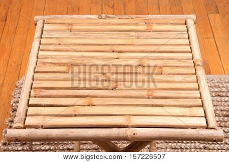 Natural bamboo folding table on jute pile hand woven area rug