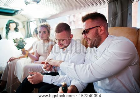 Stylish Groomsman Or Best Man Of Groom And Bridesmaids Inside Limousine At Wedding Party.