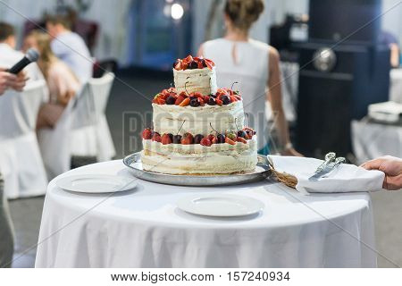 wedding cake with layers placed on a table in a restaurant in the chamber Svete variety of fruits and berries