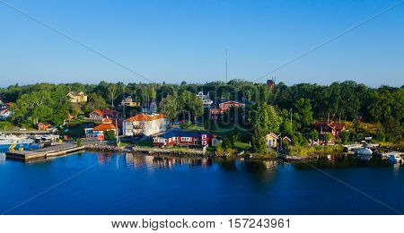 Beautiful super wide-angle aerial view of Stockholm archipelago skerries and suburbs with classic sweden scandinavian designed cottage houses from massive ferryboat