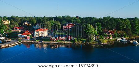 Beautiful super wide-angle aerial view of Stockholm archipelago skerries and suburbs with classic sweden scandinavian designed cottage houses from massive ferryboat
