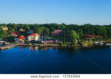 Beautiful super wide-angle aerial view of Stockholm archipelago skerries and suburbs with classic sweden scandinavian designed cottage houses from massive ferryboat