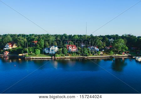 Beautiful super wide-angle aerial view of Stockholm archipelago skerries and suburbs with classic sweden scandinavian designed cottage houses from massive ferryboat