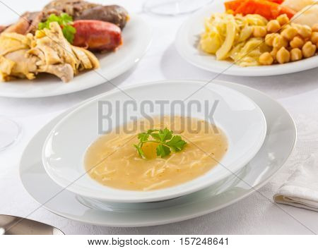 Cocido Madrileño is a delicious Spanish stew with chickpeas sausages potatoes cabbage and various types of meat.