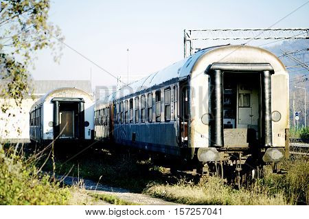 Two old trains falling apart at the train station