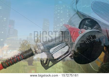 Double exposure refilling the car fuel on a filling station with city scape and natural background. Green energy concept.