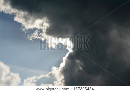 Dark storm clouds moving in from the right almost covering the blue sky