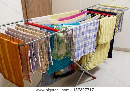 Wet towels hanging and drying on collapsible clotheshores lines indoors