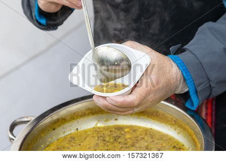 Street food - Stallholder selling corn soup into a plastic bowl. All potential trademarks are removed.