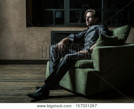 Businessman sitting on an armchair. Fahion man.