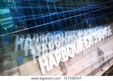 Multiple exposure effect image. Office workers walking against of Harbour Exchange sign