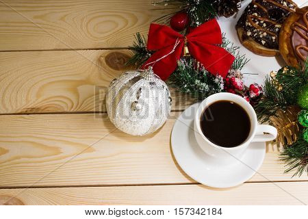A cup of coffee with fir branches and Christmas decorations. Christmas background.