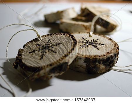Christmas decorations with pyrography. Sliced a branch Christmas decorations.