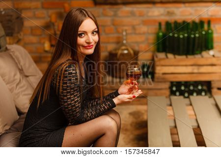 Woman Tasting Wine In Rural Cottage Interior