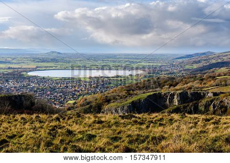 Cheddar Resevoir and the Somerset Levels from Cheddar Gorge. Bristol Water lake seen from high vantage point with limestone cliffs of canyon in foreground