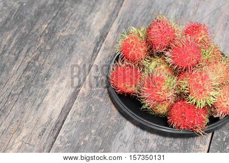 rambutan sweet fruit fresh in plate on wood background :Select focus with shallow depth of field.