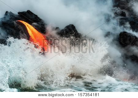 Waves crash onto molten lava flowing into Pacific Ocean on Big Island of Hawaii