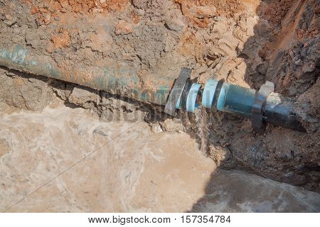 Workers repair the plumbing broken pipe and water flow in hole