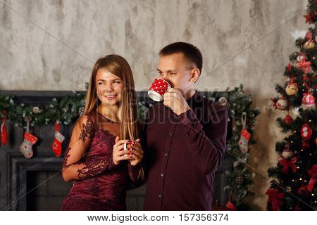 Loving couple and Christmas. Man and woman drinking from mugs Hot Christmas drink. Hot chocolate.