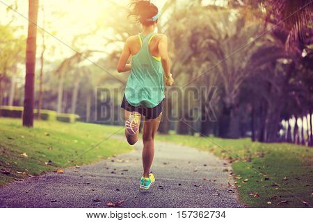 healthy lifestyle young sporty asian woman running at tropical park