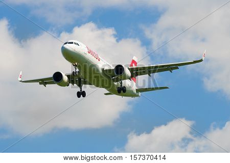 SAINT-PETERSBURG, RUSSIA - JUNE 29, 2015: Airplane Airbus A320 (HB-JLT) company Swiss International Air Lines in a cloudy sky