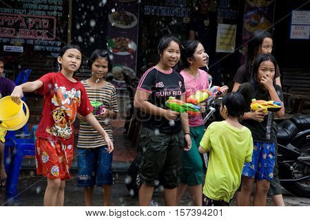 Bangkok, Thailand - April 13, 2008 : 
During Songkran the Thai New Year's festival. Teenagers watering passers-by on the street.