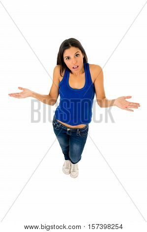 young attractive hispanic woman in casual top and jeans shrinking shoulders open arms wondering confused in doubt isolated on white background