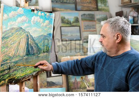 Artist Paints Oil Painting With A Brush And Palette