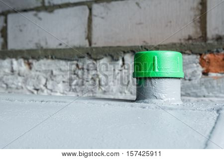 in a separate room in a old building there is a heating oil tank and a filler green cap in closeup