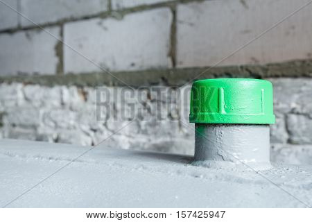 in a separate room in a old building there is a heating oil tank and a filler green cap in closeup